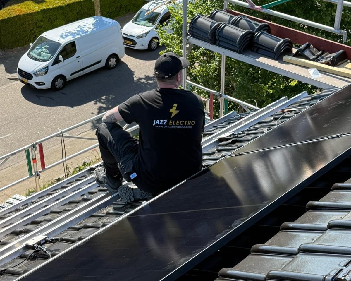 Monteur plaatst zonnepanelen op pannen dak - Jazz Electro